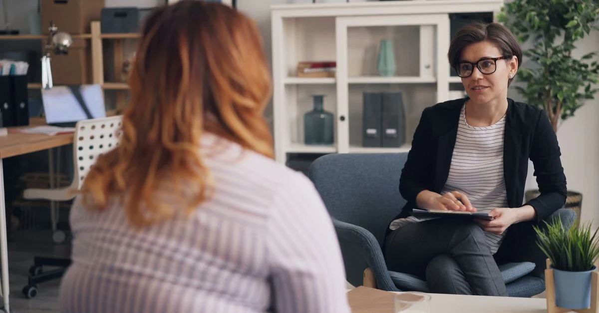 Deux femmes s'engagent dans une séance de thérapie dans un bureau confortable.