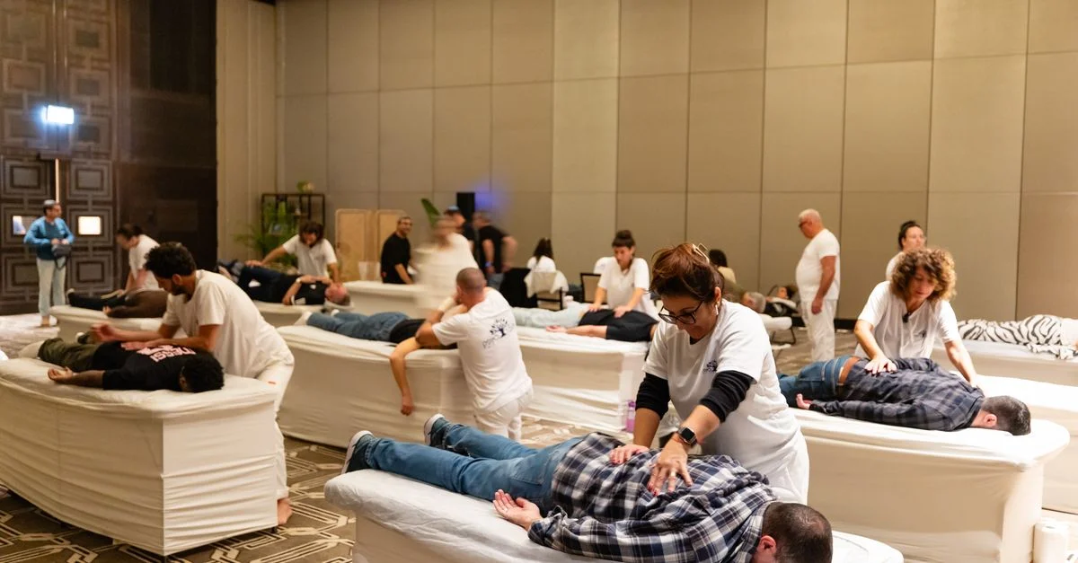 Un groupe de thérapeutes dispensant des massages lors d'une séance de bien-être en intérieur.